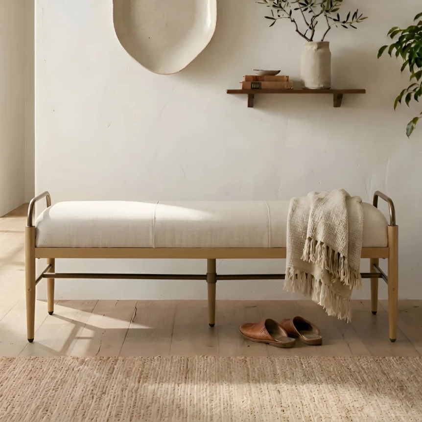 Modern upholstered bench with wooden frame and white cushion in minimalist entryway with decorative shelf and mirror