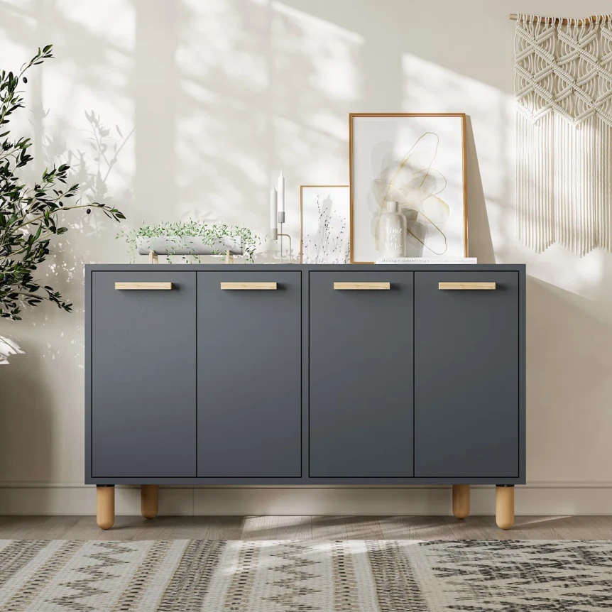 Modern gray sideboard console table with wooden legs and brass handles in bright entryway with natural light