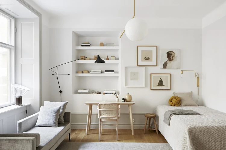 Scandinavian style studio apartment with light wood furniture and neutral bedding in compact layout