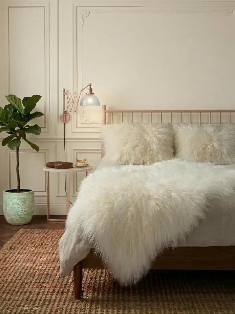 Cozy bedroom with white fluffy bedding, neutral tones, and minimalist Scandinavian hygge decor
