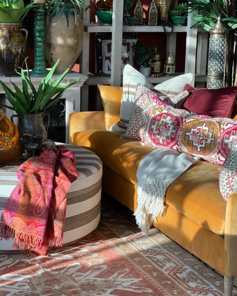 Bohemian living room with mustard velvet sofa, mixed patterned pillows, colorful throws, and layered textiles
