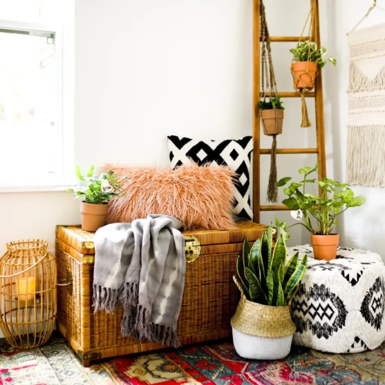Wicker storage trunk with colorful pillows, ladder shelf with plants, and patterned rug creating bohemian decor style