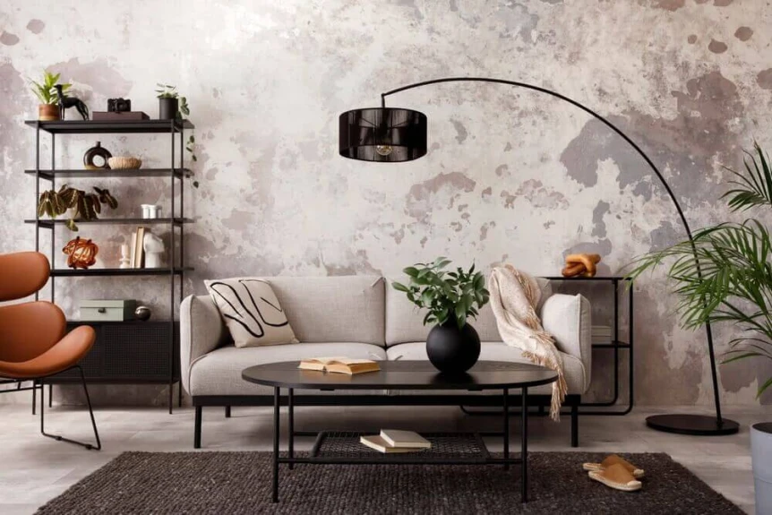 Modern industrial living room with arc lamp, grey sofa, metal shelving, exposed concrete wall and neutral tones