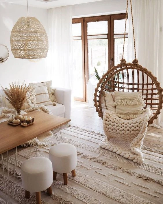 Boho-inspired living room with hanging rattan chair, woven pendant light, and neutral tones in Scandi style