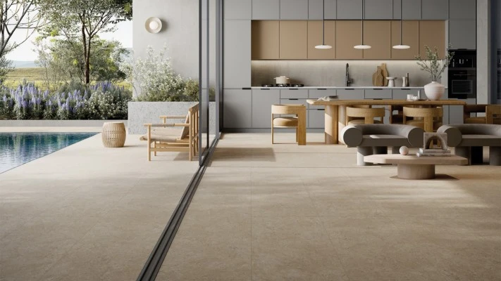 Modern indoor-outdoor living space with seamless floor transition connecting kitchen to pool area