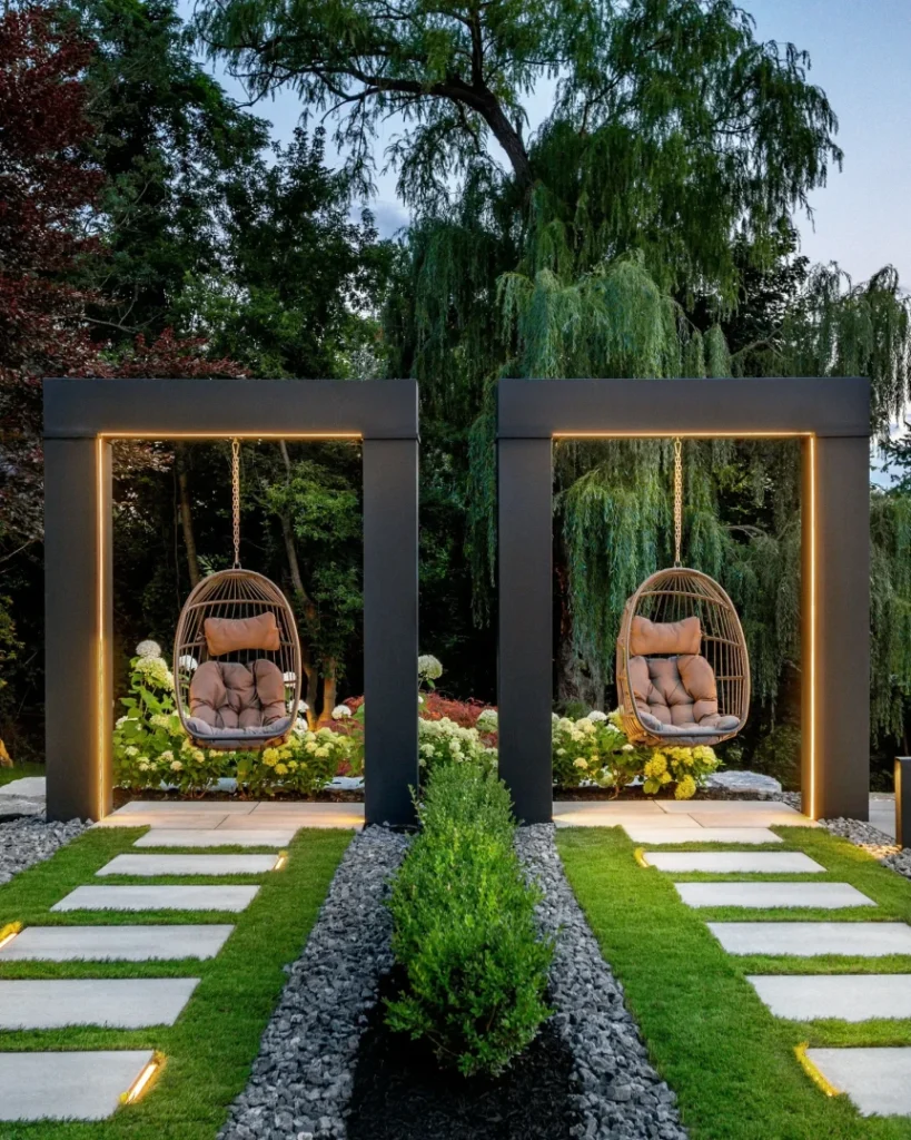 Modern patio with wooden pergolas, stepping stone pathways, hanging egg chairs, and lush garden landscaping for relaxation