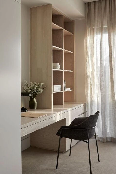 Minimalist Japandi home office with floating wooden desk, geometric shelving, and black accent chair