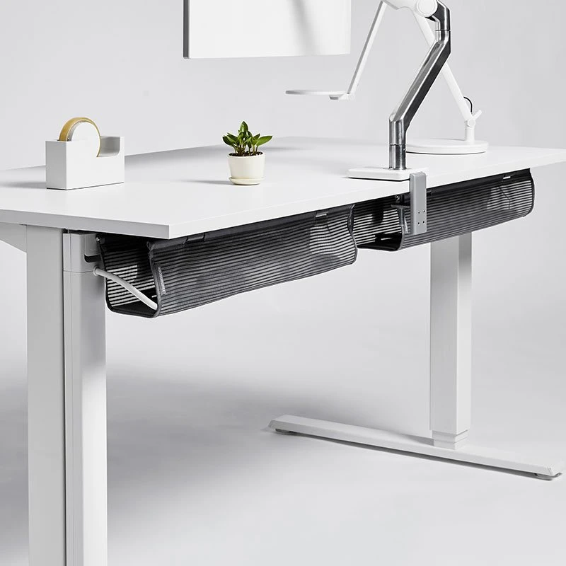 Modern white height adjustable desk with a built in cable management tray running the length of the underside and a tidy ergonomic workspace above