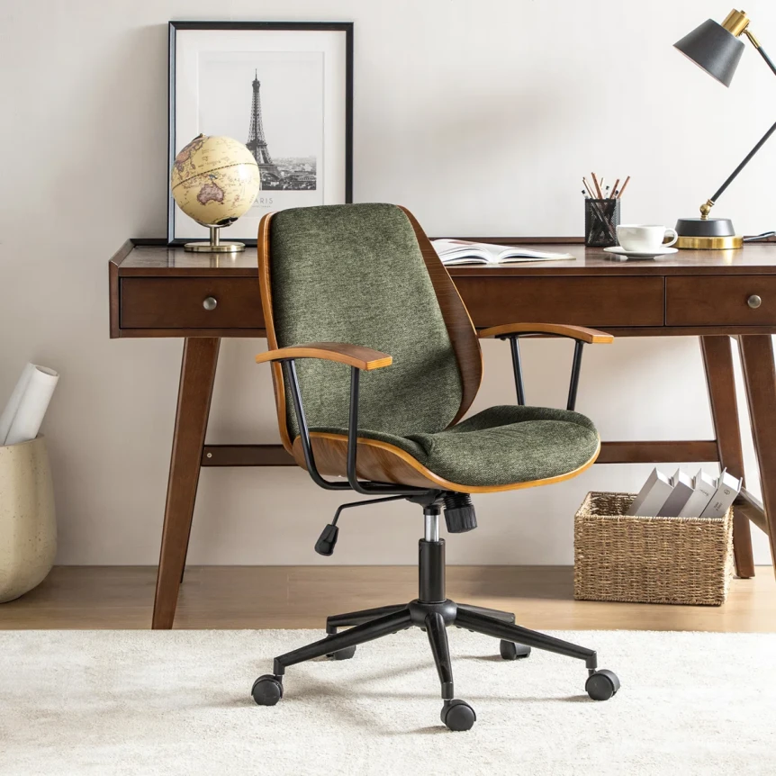 Mid century modern home office with a green velvet desk chair, walnut desk with tapered legs, and minimalist decor on a brass accented shelf