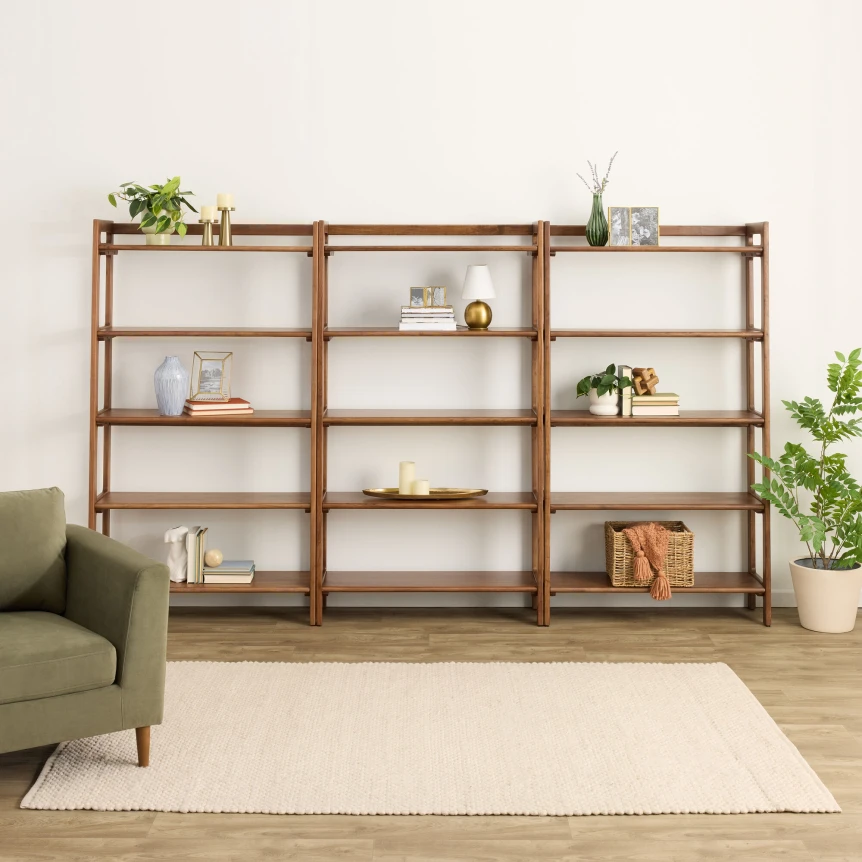 Wooden ladder shelf unit with minimalist decor displayed in modern living room with green sofa and plants