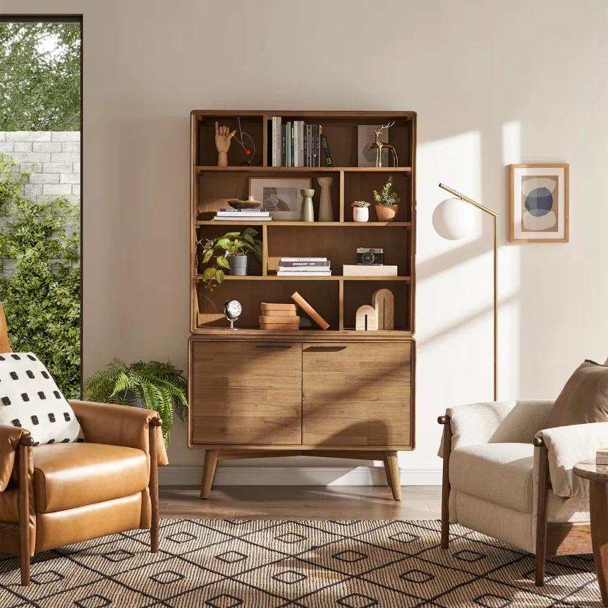 Mid-century modern bookshelf with open shelving and cabinet storage in contemporary living room with leather chairs