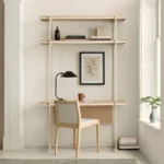 Minimalist Scandinavian wall-mounted desk with light wood shelving and chair in bright white small home office