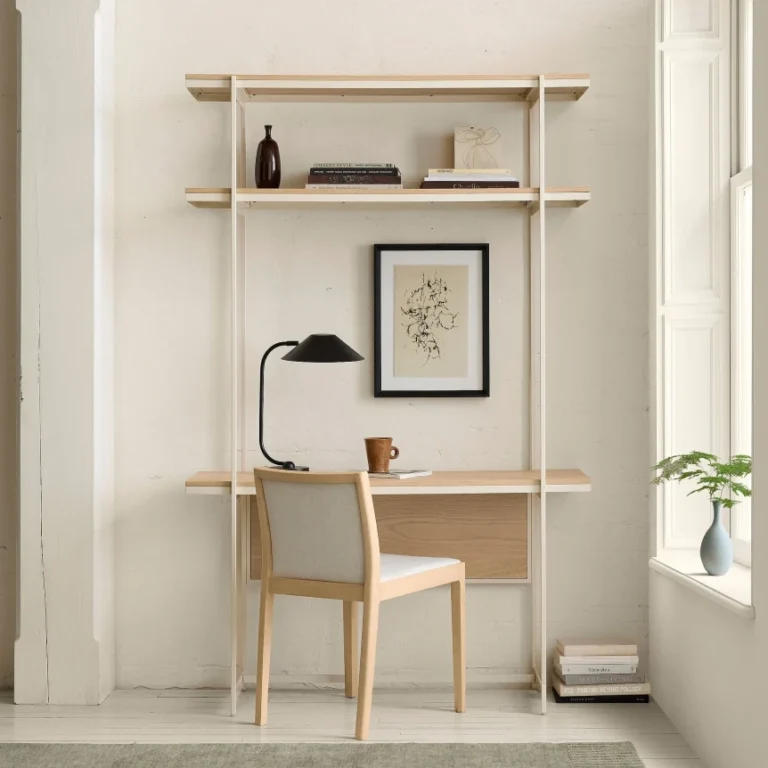 Minimalist Scandinavian wall-mounted desk with light wood shelving and chair in bright white small home office