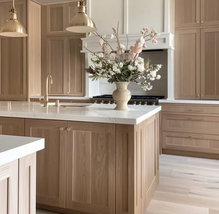Modern kitchen with natural wood cabinets, white marble countertops, and elegant floral centerpiece
