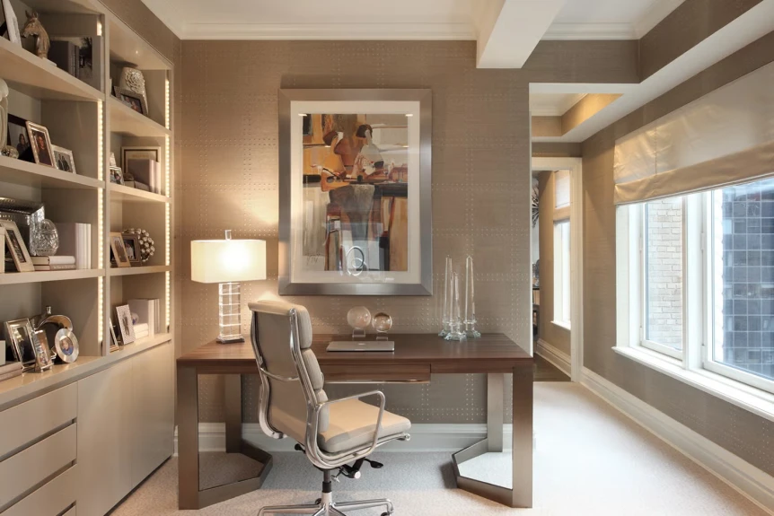 Modern home office with built-in white bookshelves, wooden desk, ergonomic chair, and large window with natural light