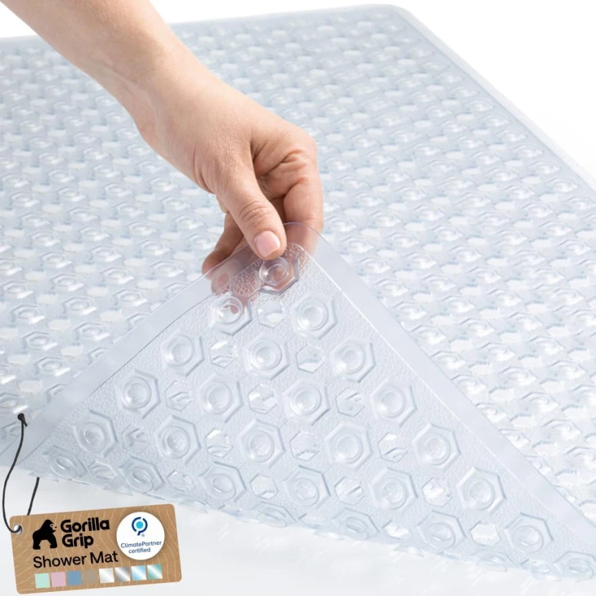 Non-slip shower mat with suction cups being placed in bathtub for bathroom safety