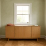 Light oak sideboard in minimalist living room with pale green walls and herringbone wood floor