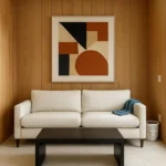 Cream fabric sofa in modern living room with wood panel walls and abstract art in warm tones